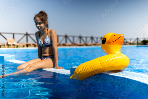 Girl sitting near the pool laughing and enjoying summer vacation © YouraPechkin