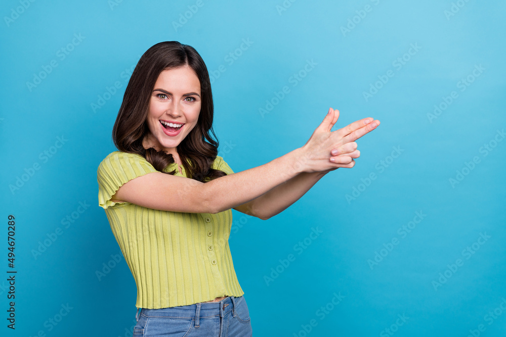 Photo of impressed millennial brunette lady play wear t-shirt isolated on blue background Photo of impressed millennial brunette lady play wear t-shirt isolated on blue background