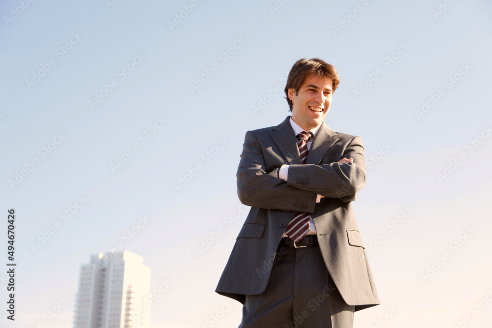 Hombre de negocios sonriendo junto a edificio de oficinas Hombre de negocios sonriendo junto a edificio de oficinas