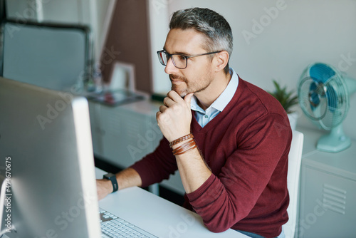 Giving some thought to his innovative ideas. Shot of a mature businessman working on a computer in an office.