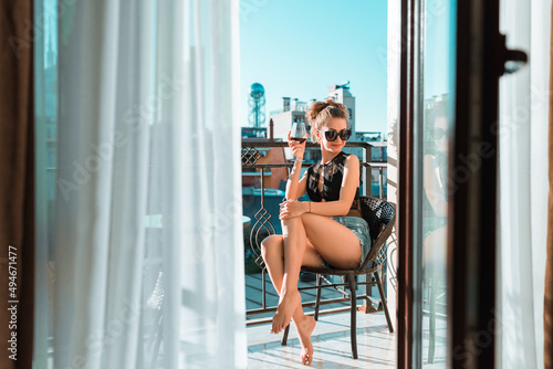 Wallpaper Mural Young female girl enjoying the view on a balcony with a glass of wine Torontodigital.ca