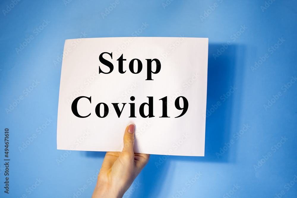 man hand holding blank card paper sheet isolated on blue background with copy space.Holding a sign that says Covid 19 man hand holding blank card paper sheet isolated on blue background with copy space.Holding a sign that says Covid 19