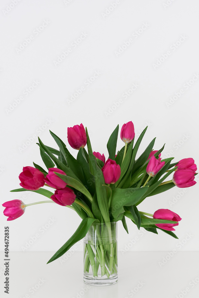 Bouquet of pink tulips in a transparent vase. Pink flowers. Minimal and simple home decor Bouquet of pink tulips in a transparent vase. Pink flowers. Minimal and simple home decor