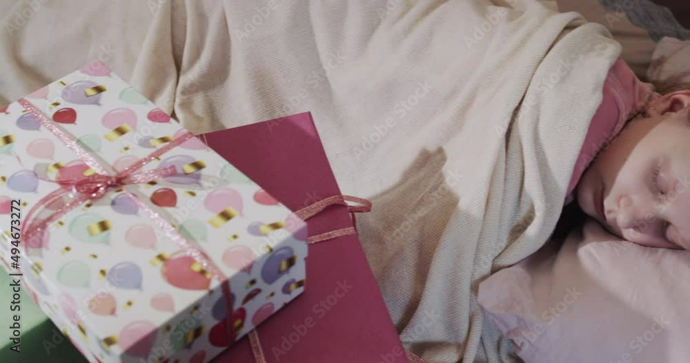 A child sleeps in his bed, next to gift boxes and balloons. Pan shot A child sleeps in his bed, next to gift boxes and balloons. Pan shot