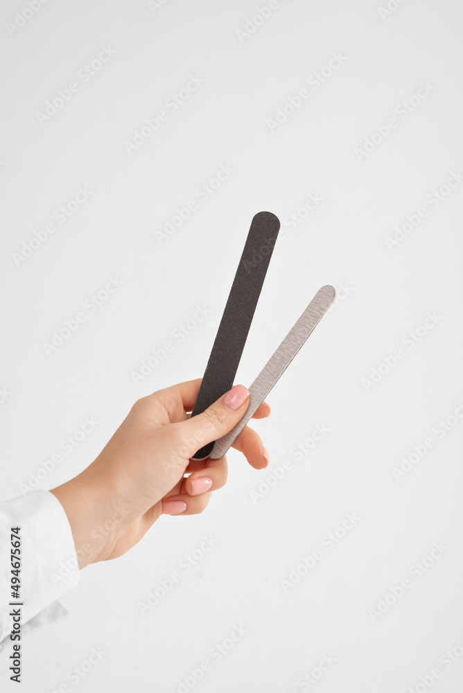 a hand with a nail file on white background with copy space a hand with a nail file on white background with copy space