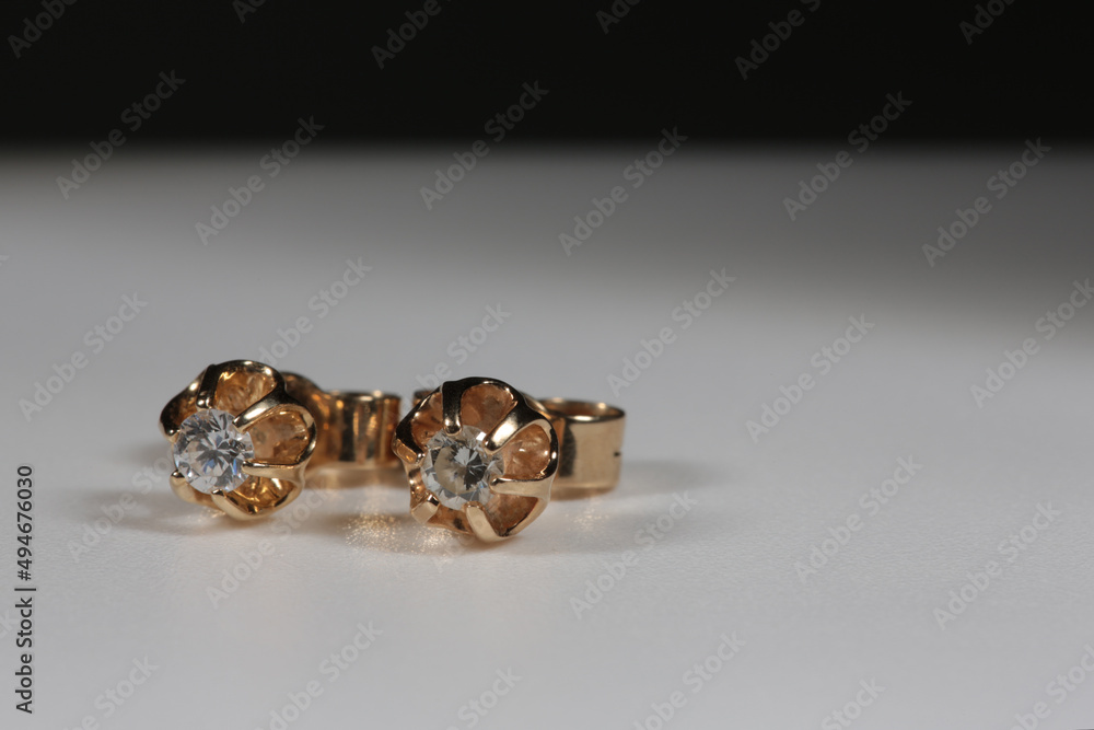 Yellow gold earrings with natural round diamonds on a white background Yellow gold earrings with natural round diamonds on a white background
