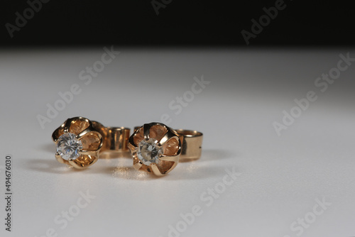 Yellow gold earrings with natural round diamonds on a white background
