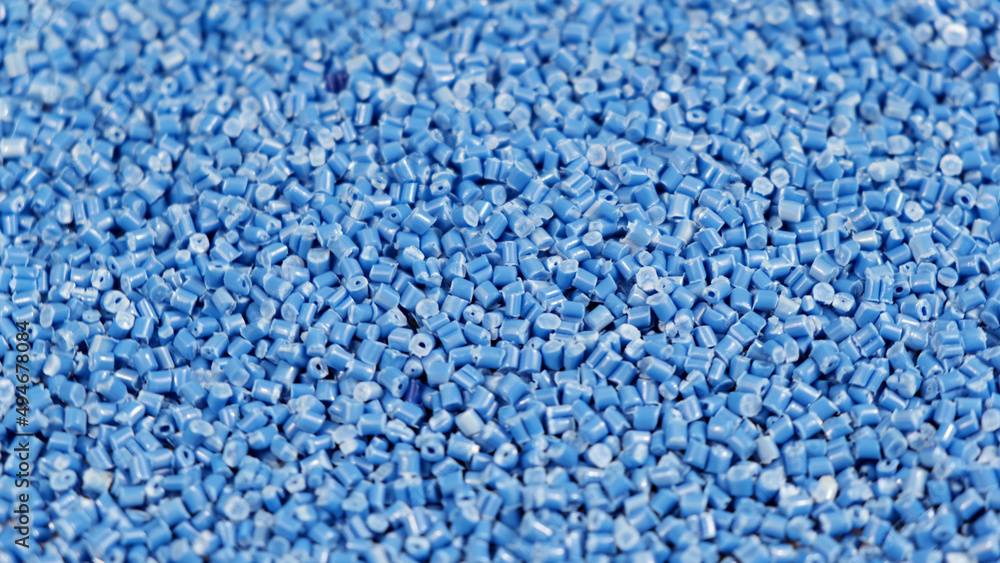 Secondary granule made of polypropylene, Blue Plastic pellets crumbles to the table. Plastic raw materials in granules for industry. Polymer resin. Raw plastic recycling concept