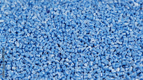 Secondary granule made of polypropylene, Blue Plastic pellets crumbles to the table. Plastic raw materials in granules for industry. Polymer resin. Raw plastic recycling concept photo