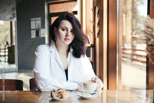 Plus size elegant woman in city in coffee shop, plump lady lifestyle