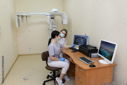 Two concentrated dentists looking at x-ray on computer
