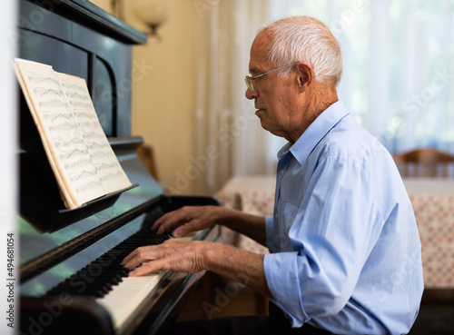 Senior man learning to play piano