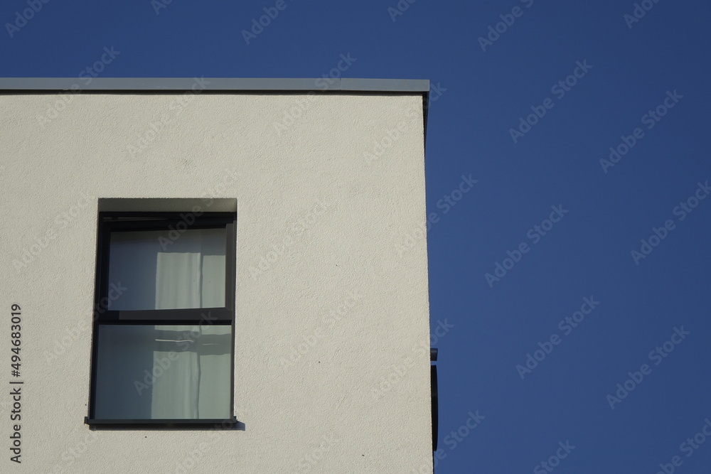 Upper right corner of white house wall with single window, clear blue sky, use: copy space, texture, background (horizontal), Kaiserslautern, RLP, Germany