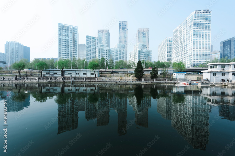 City buildings are reflected on the river