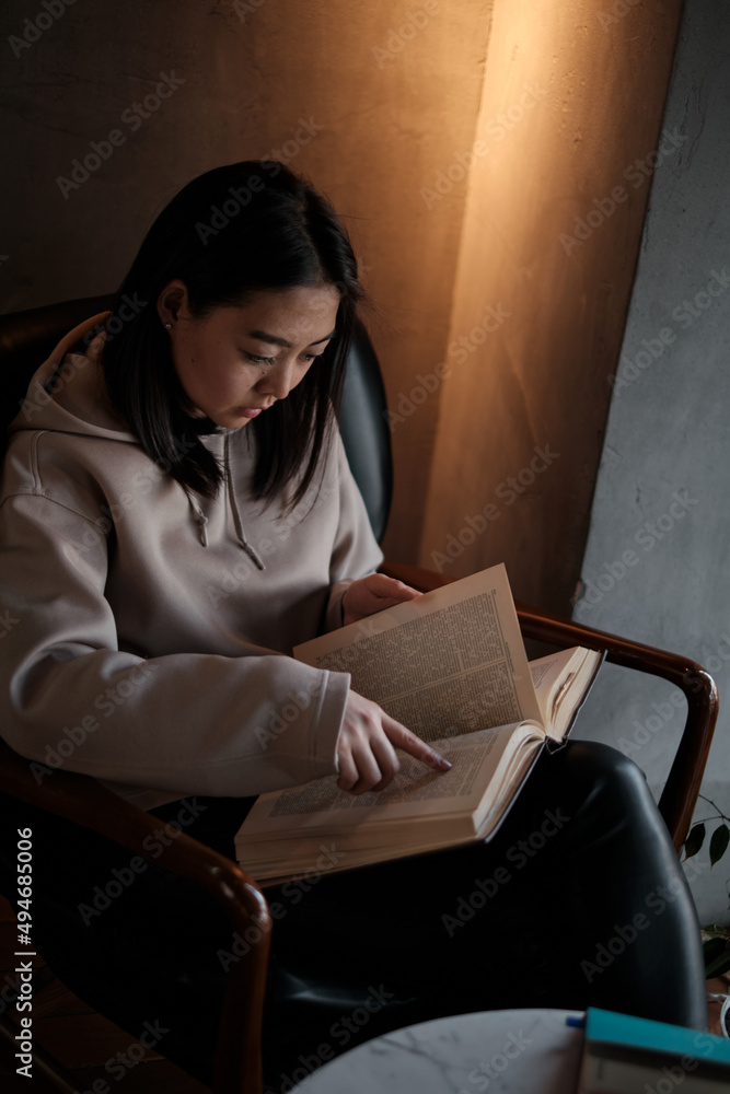 Shot of young asian female student sitting at table and writing on notebook. Young female student studying in cafe. Shot of young asian female student sitting at table and writing on notebook. Young female student studying in cafe.