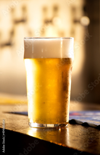 Fotografia English pint of pale lager or chilled lager at pub counter