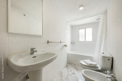 Bathroom with shower cabin with curtain  white sink under mirror with fine white wood frame  stoneware floors