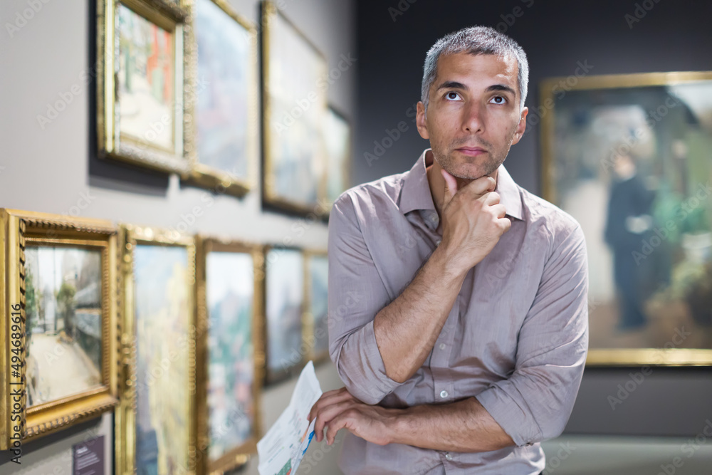 © JackF - Man is looking at the exposition in the picture gallery.