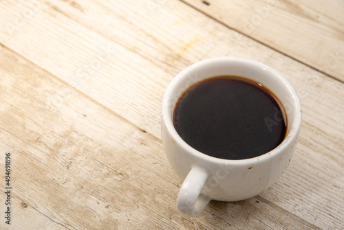 Coffee in a glass on a wooden floor The drink is popular all over the world. Products from Asia and Blasil