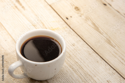 Coffee in a glass on a wooden floor The drink is popular all over the world. Products from Asia and Blasil