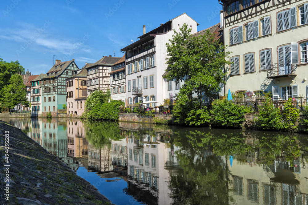 Timbered Houses reflecting in the ILL canal along the riverbank of the Petite France, Strasbourg, Alsace, Bas-Rhin Department, France