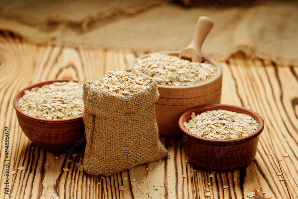 Оatmeal in bowls and bags on a wooden background. High quality photo Оatmeal in bowls and bags on a wooden background. High quality photo