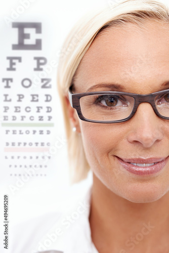 Shes a sight for sore eyes. A cropped shot of a beautiful optometrist in front of a snellen chart.