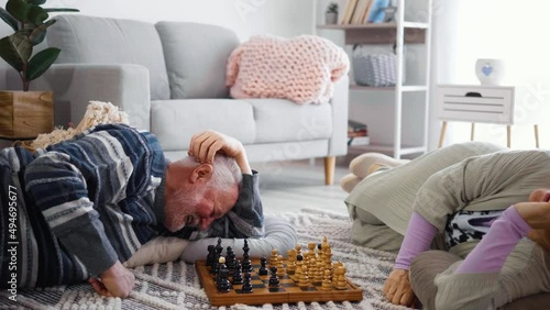 Seniors playing a chess game on the floor in a cozy nursing home