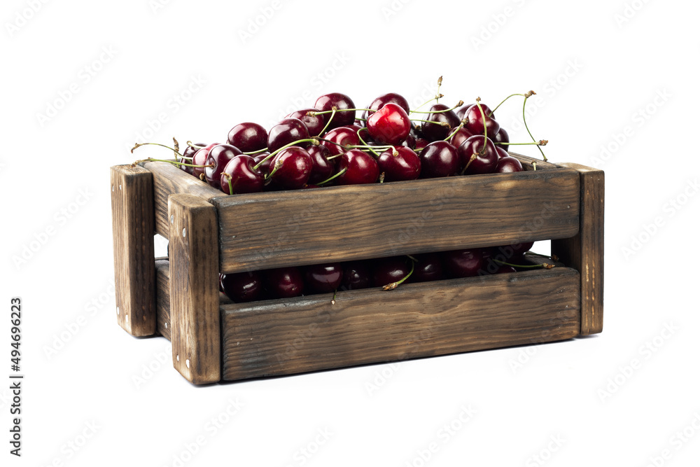 Cherry in box. Sweet fresh cherry in wooden brown box on white background.