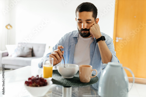 Fototapeta Depressed man at the table suffering from lack of appetite