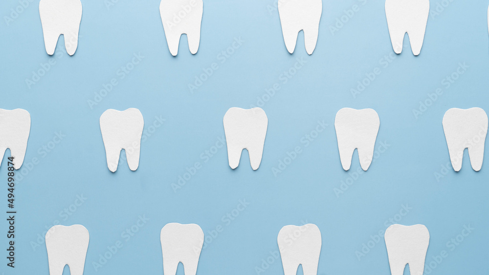 Top view of white teeth shape made from paper on light blue backgrond. Dental concept. Minimal. Top view of white teeth shape made from paper on light blue backgrond. Dental concept. Minimal.