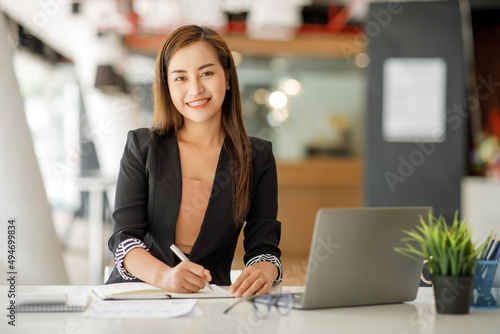 Portrait of Charming Asian businesswoman sitting working on laptop computer in the office.