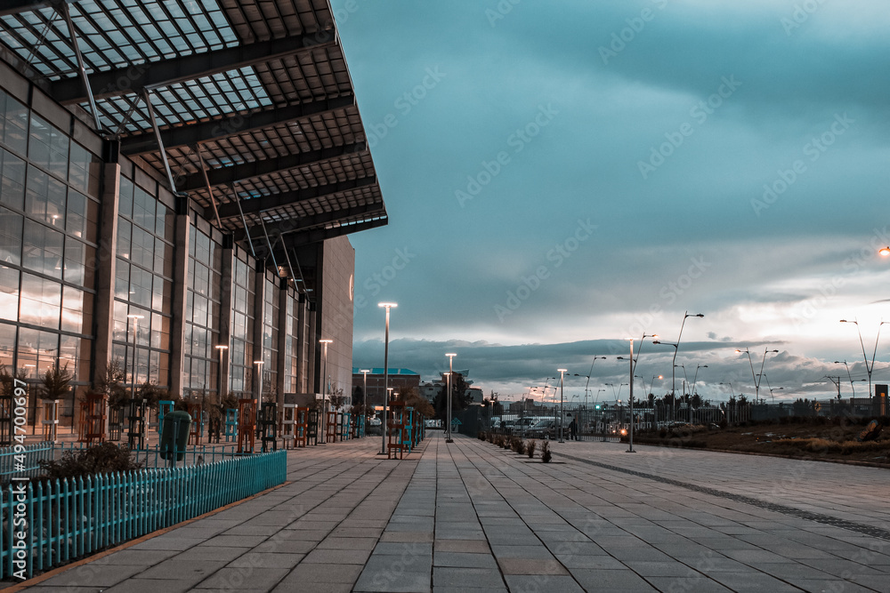 Empty urban landscape perspective building background cobblestone floor cloudy sky and street lights sunset