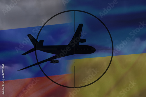 Flight safety and armed conflict, the silhouette of the aircraft against the background of the flags of Russia and Ukraine in the sight of the gun.
