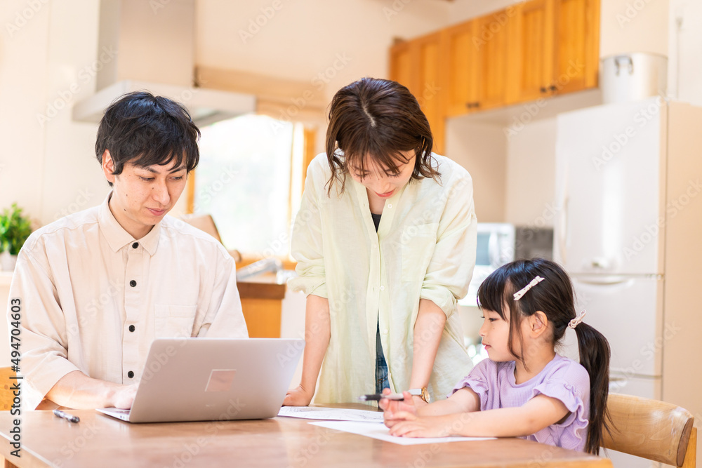 テレワークをする夫婦と子供