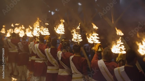 Group Of Priest Holding Fire Lamps In Ganga Rivershore During Aarti At Triveni Ghat In Rishikesh, India. Medium Shot