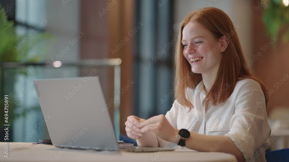 happy redhead woman is chatting online by web, talking to camera of laptop and smiling, remote communication technology happy redhead woman is chatting online by web, talking to camera of laptop and smiling, remote communication technology