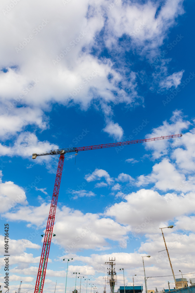 Tall red crane works under blue sky background Tall red crane works under blue sky background