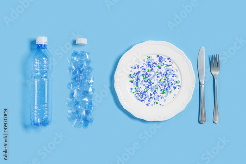 White plate full of microplastics on blue background with copy space. Plastic pollution concept, global ocean pollution ecology problem, microplastic particles in water and food, top view photo