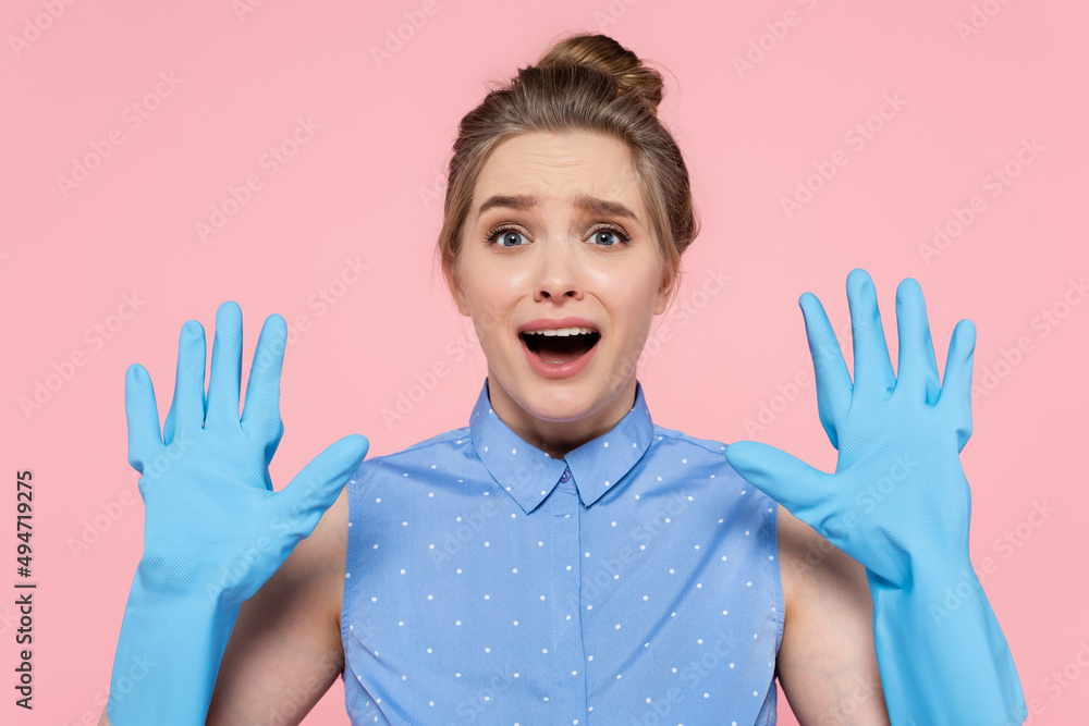 shocked woman showing hands in blue rubber gloves isolated on pink. shocked woman showing hands in blue rubber gloves isolated on pink.