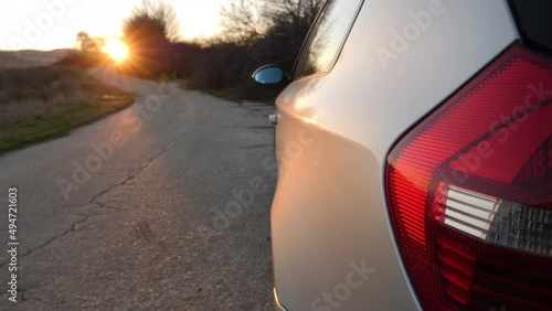 Car parked on the side of the road at sunset.  photo