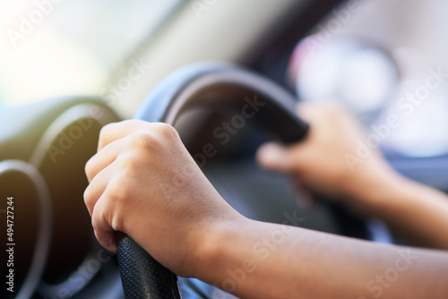 Enjoy the journey. Shot of hands holding onto a steering wheel while driving.