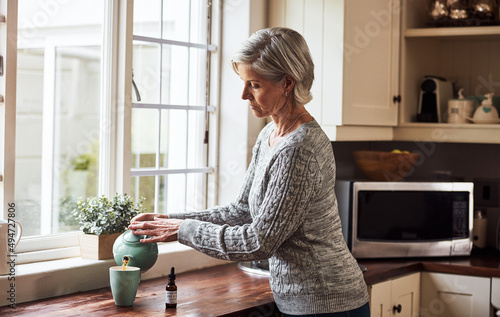 This is going to sort me out. Cropped shot of a relaxed senior woman preparing a cup of tea with CBD oil inside of it at home during the day.