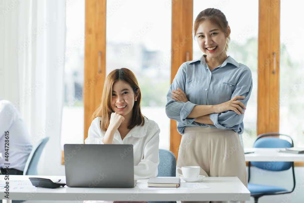 2 businesswomen working on line watching webs in a laptop in a bar with a window and and outdoors in the background 2 businesswomen working on line watching webs in a laptop in a bar with a window and and outdoors in the background