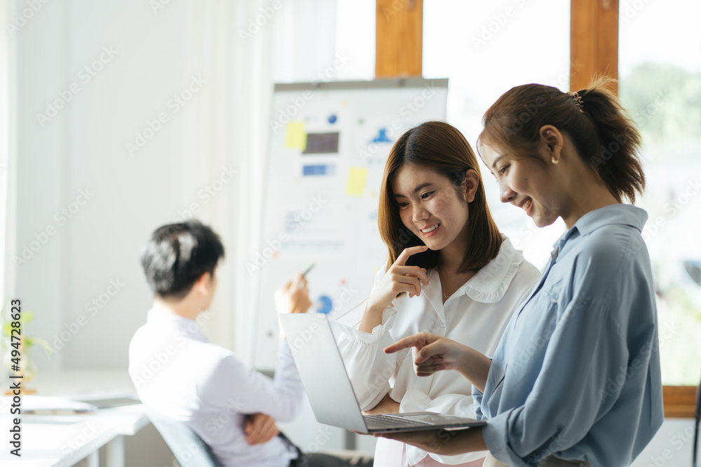 Two asian female collegues standing next to each other in an office, business meeting discussion concept. Two asian female collegues standing next to each other in an office, business meeting discussion concept.