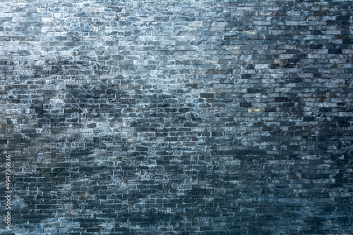 Black brick wall with gradient sunlight by top left to bottom right. Can used for background.