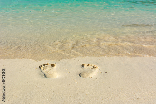 Footprint on the beach next to sea wave. Can used for travel concept or alone concepts.