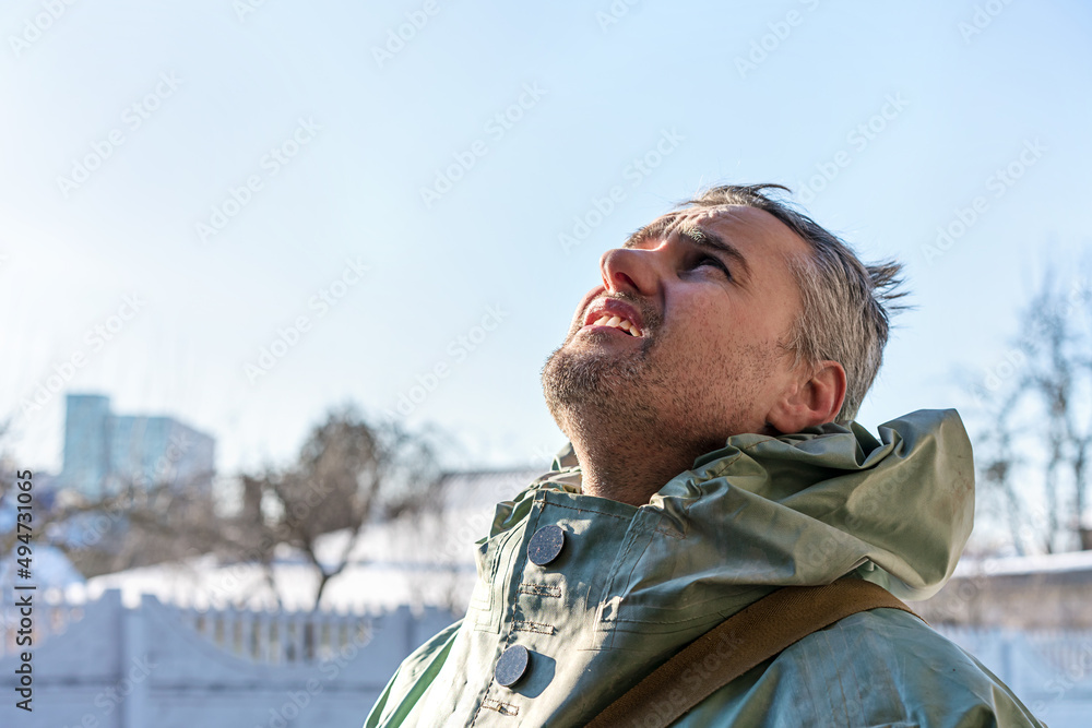 Side view portrait of middle aged man wearing protective costume and looking up with hope to blue clear sky Side view portrait of middle aged man wearing protective costume and looking up with hope to blue clear sky