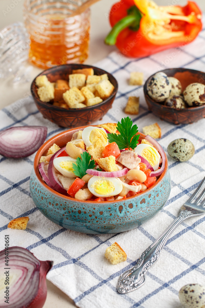 Delicious salad of chicken fillet, bell pepper, white beans, quail eggs, bread croutons, red onion and parsley with a sauce of olive oil, mustard and honey. Selective focus Delicious salad of chicken fillet, bell pepper, white beans, quail eggs, bread croutons, red onion and parsley with a sauce of olive oil, mustard and honey. Selective focus