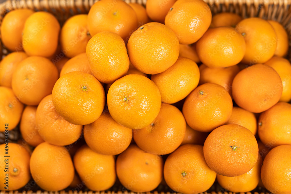 There are a lot of ripe tangerines in a wicker basket. Selective focus. There are a lot of ripe tangerines in a wicker basket. Selective focus.